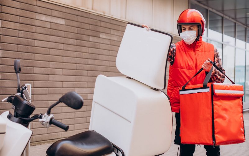 food-delivery-boy-driving-scooter-with-box-with-food-wearing-mask